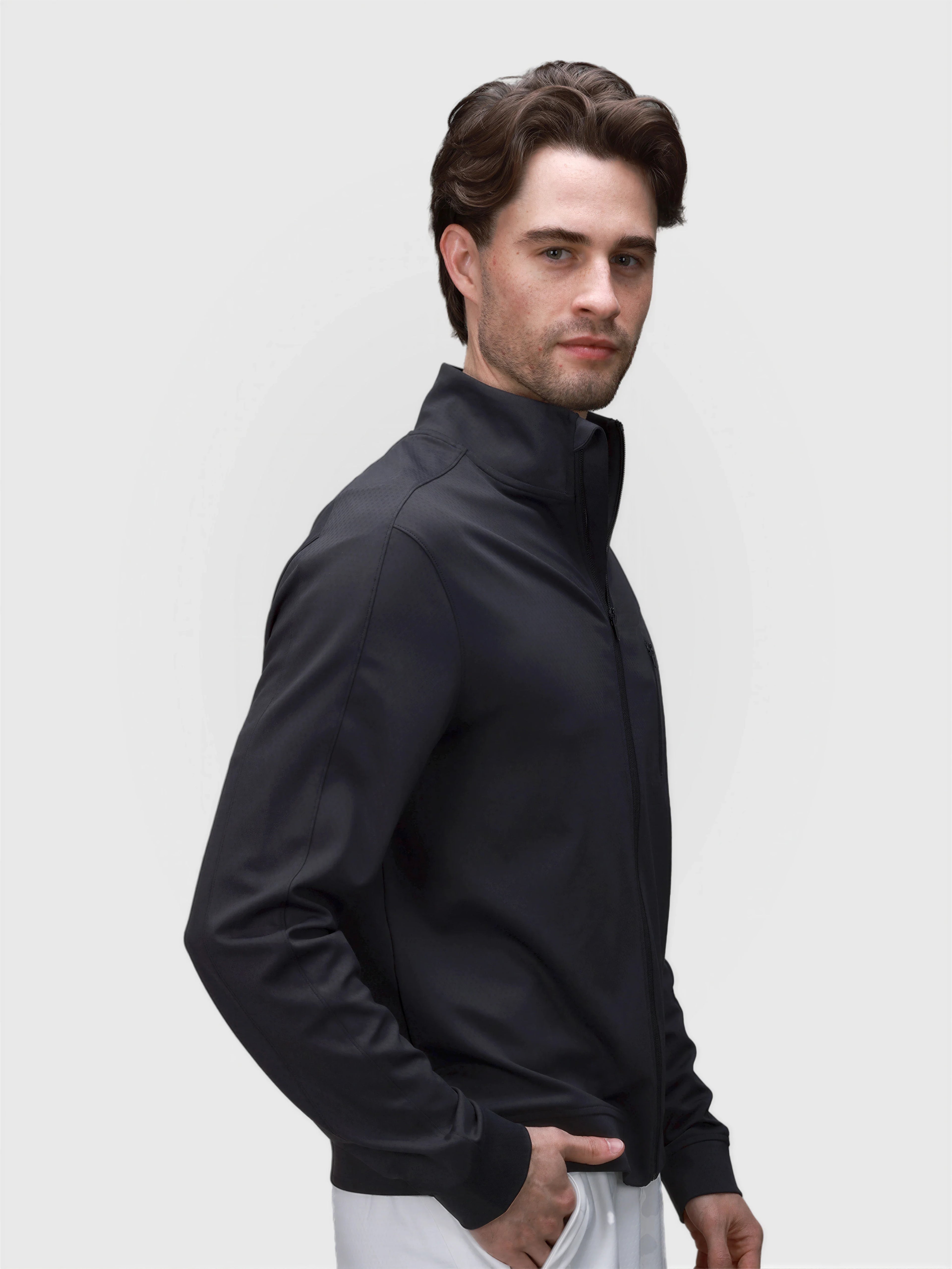 Man modeling black Echelon Jacket by MUEV in sleek padel and pickleball clothing style
