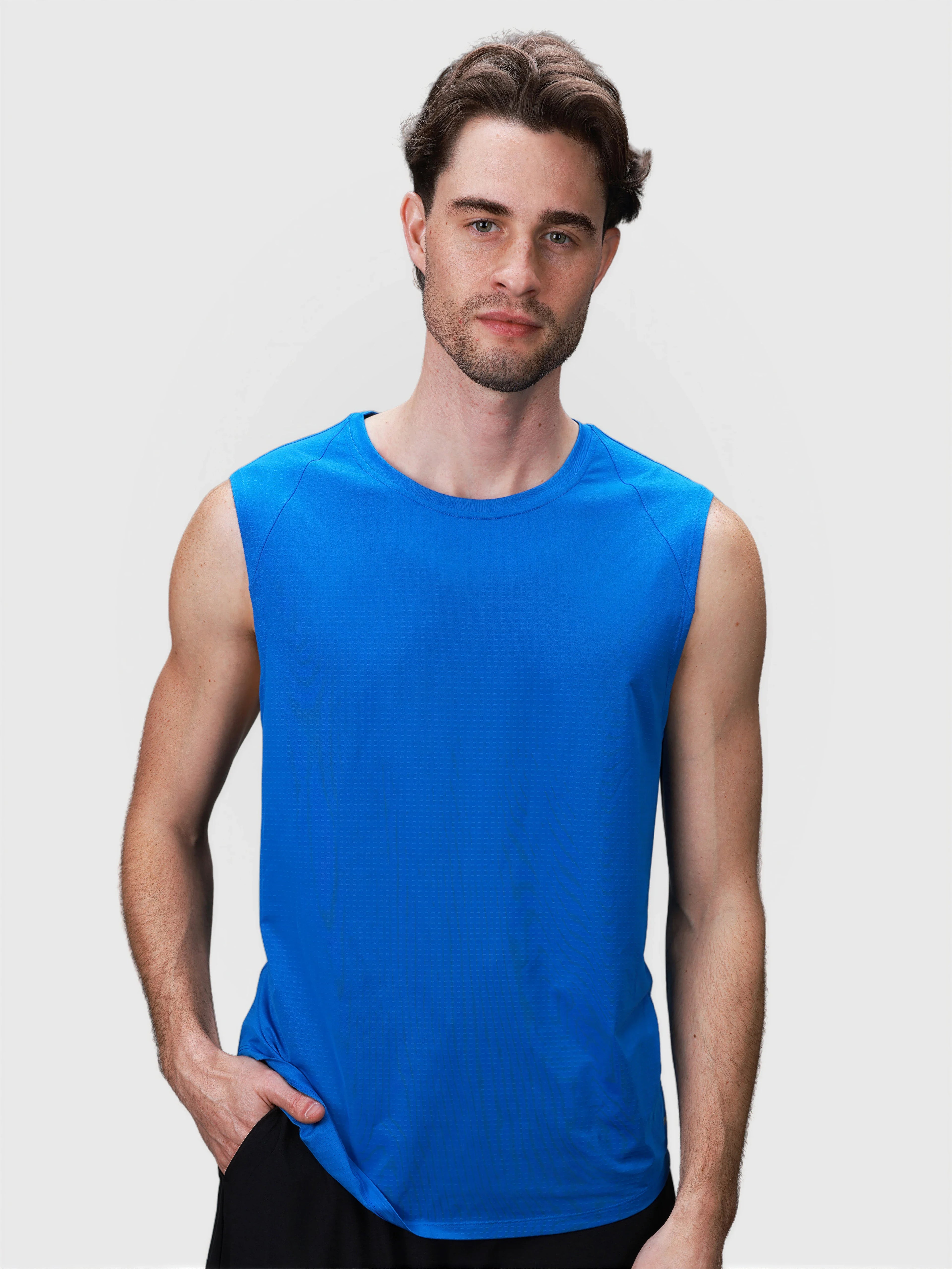 Man wearing bright blue sleeveless Dink Tank in pickleball clothing collection by MUEV shown from front view