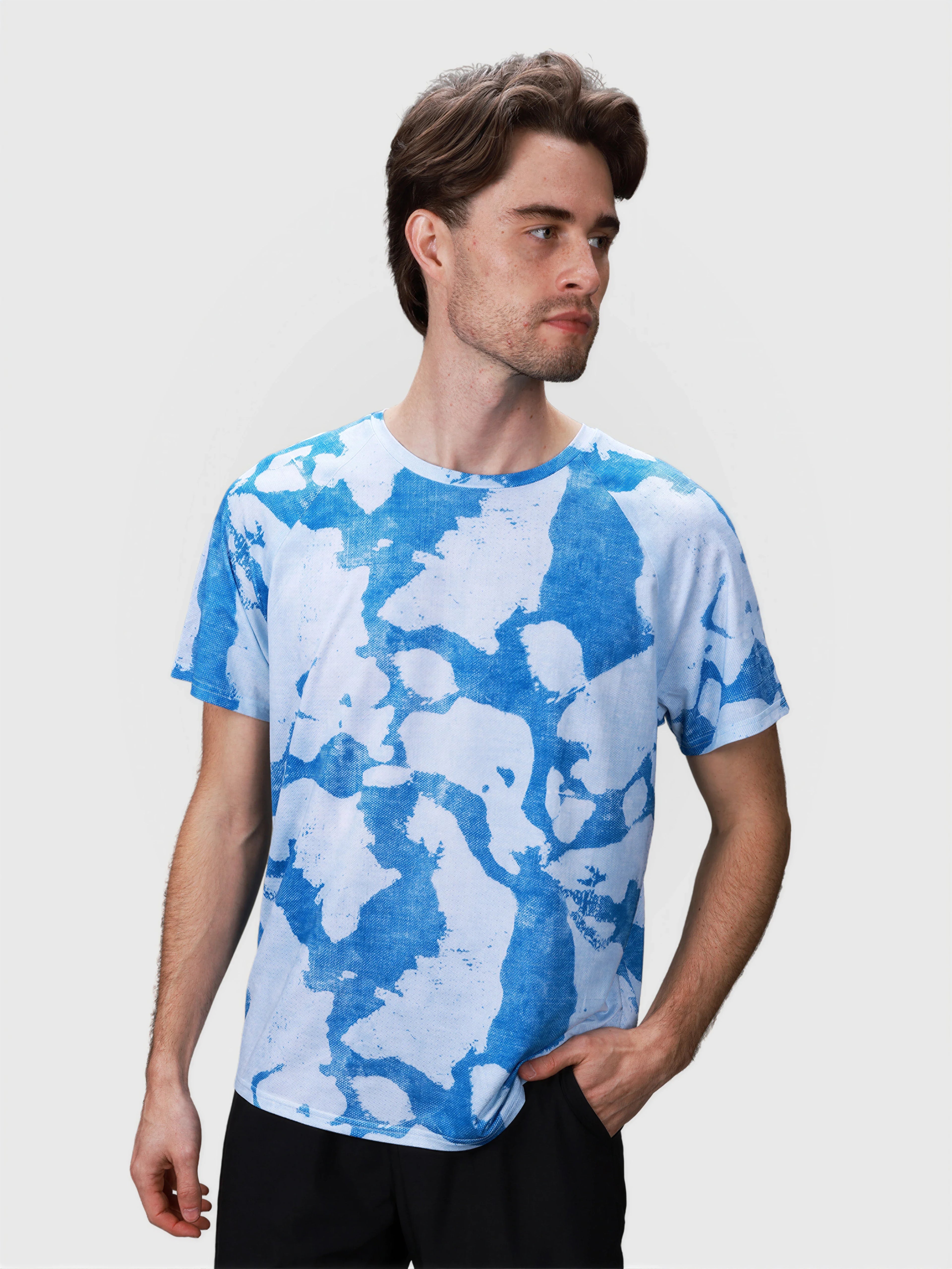 Man wearing blue and white abstract pattern Dink Performance Tee in pickleball apparel by MUEV