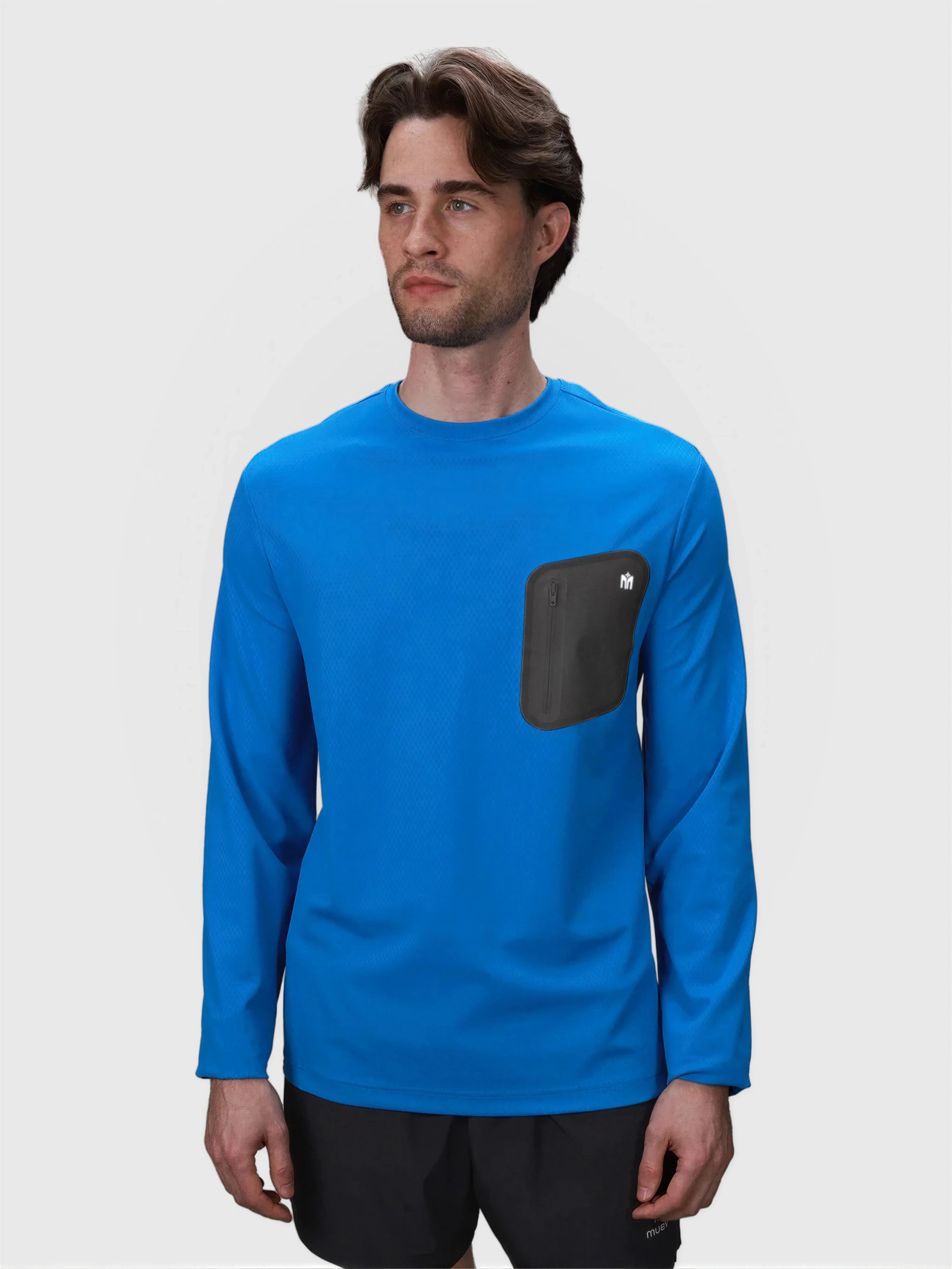 Man wearing royal blue Echelon Long Sleeve Shirt by MUEV with black zippered chest pocket for padel and pickleball apparel