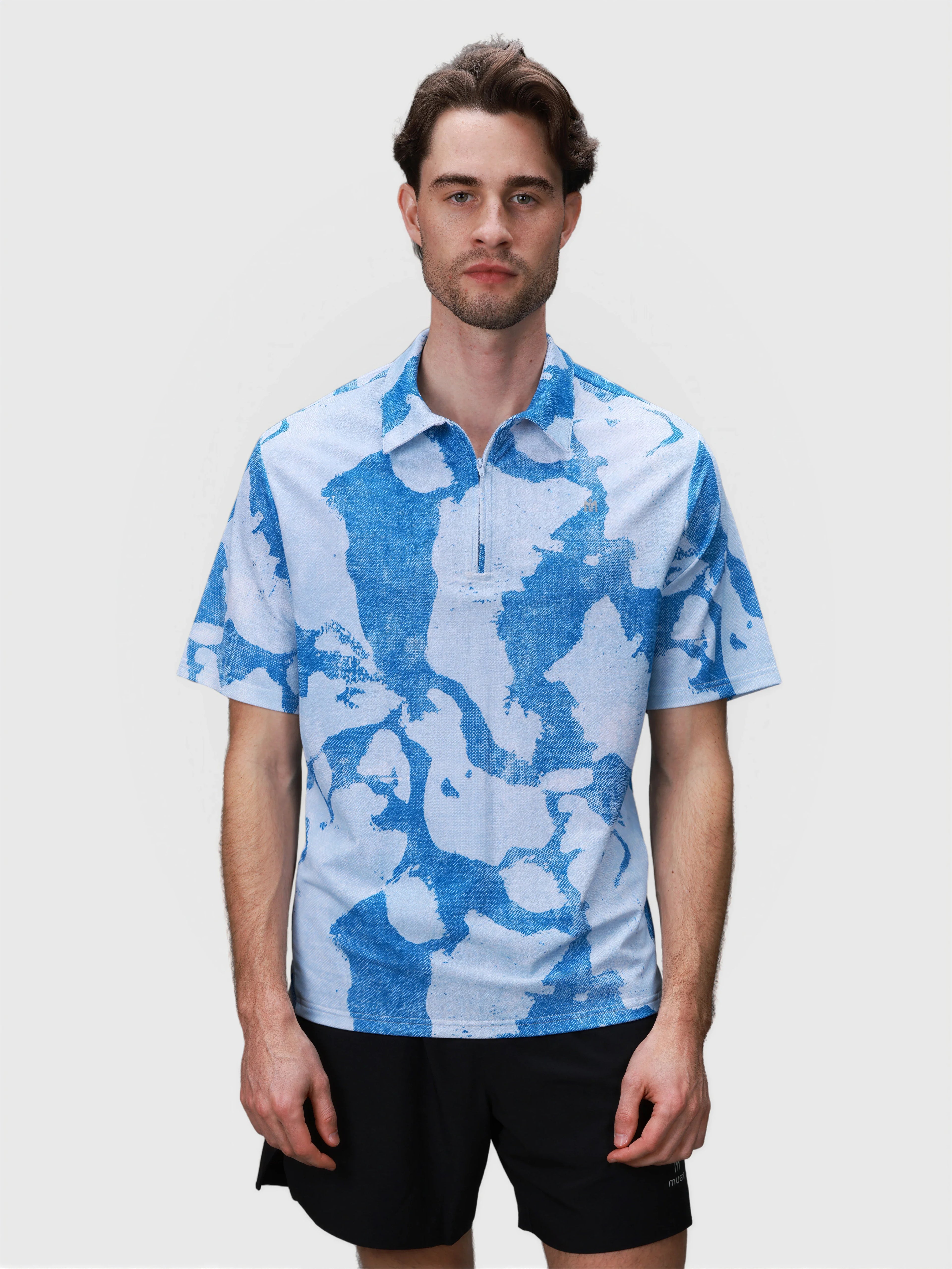 Man wearing blue and white patterned Elevate Zip Polo by MUEV designed for breathable padel and pickleball apparel
