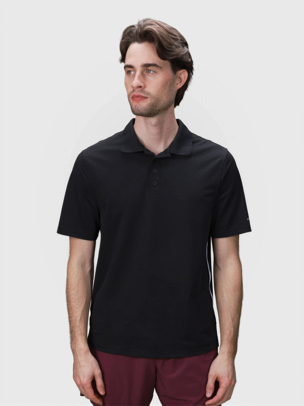 Man wearing black Tip Polo by MUEV designed for padel apparel with classic collar and button placket details